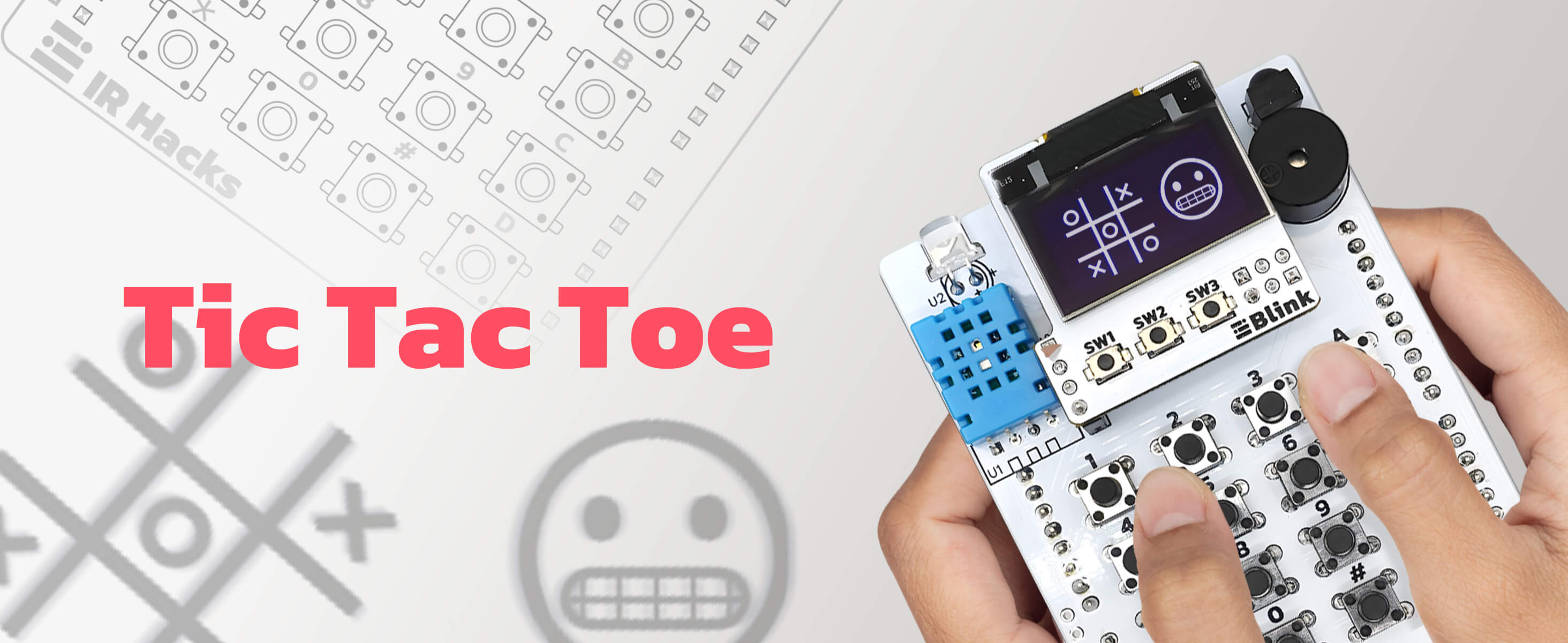 Hands playing Tic Tac Toe on the amomii IR Hacks board, its Blink OLED screen showing a noughts and crosses grid